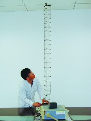 這是伸展開(kāi)的衛星太陽(yáng)能電池用盤(pán)壓伸桿，20厘米長(cháng)螺旋狀的盤(pán)壓伸桿（右側小圖）打開(kāi)后能達2米長(cháng)（8月7日攝）。（新華社發(fā)）